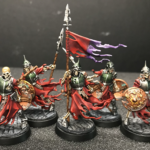 Death watch skeletons with a flag on custom green stuff cobblestone bases.