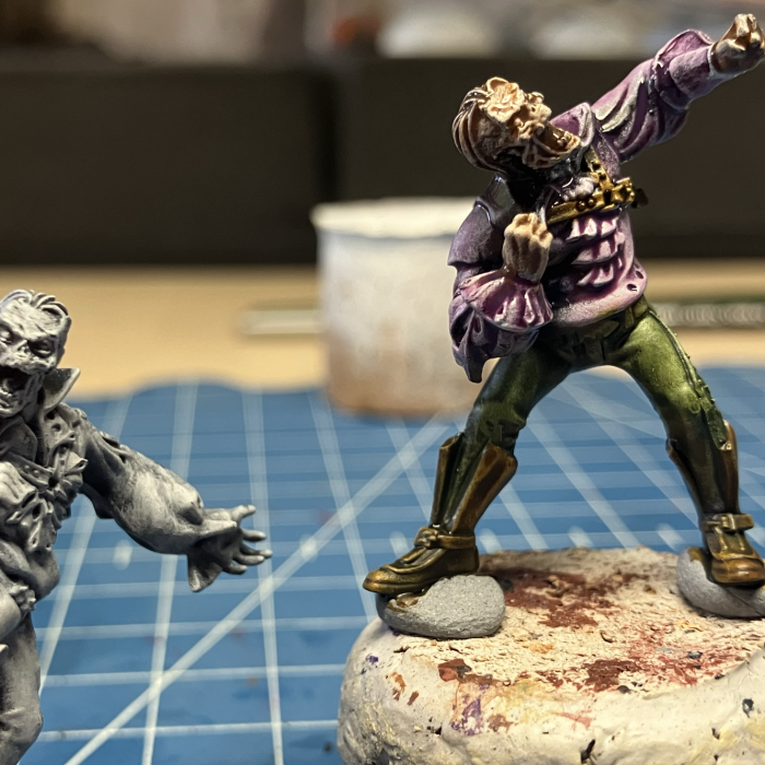 Two zombie conversions being painted in the slap chop style