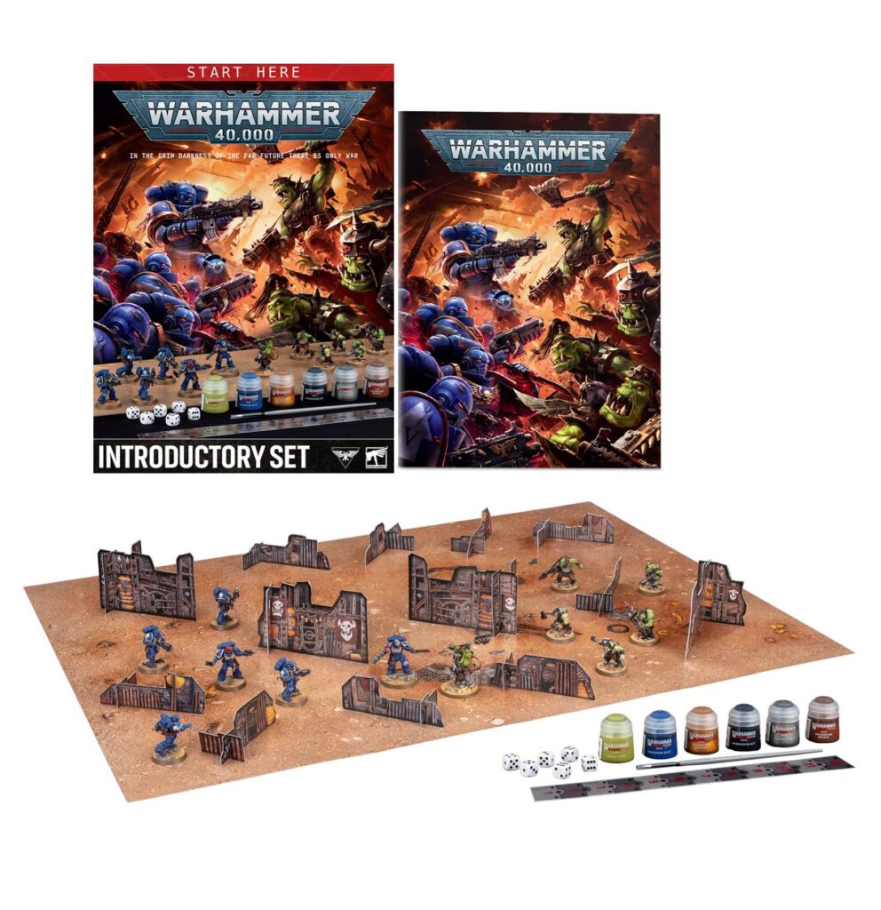 A tableau displaying the contents of the Warhammer 40,000: Introductory Set box including marines, orcs, a rules booklet, dice, and paints.