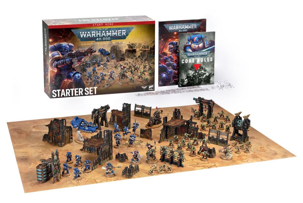 A tableau displaying the contents of the Warhammer 40,000: Starter Set box including marines, orcs, dice, rules, and a core rules book.