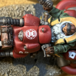 A skull logo and card stack on a red squat hoverbike.
