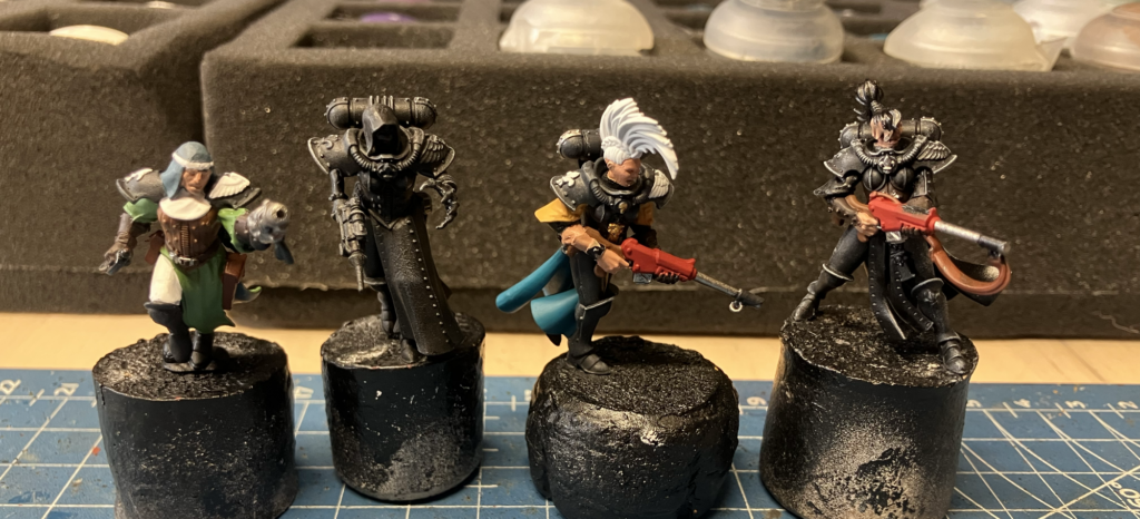 Four kitbashed Escher sisters of battle in mid-paint