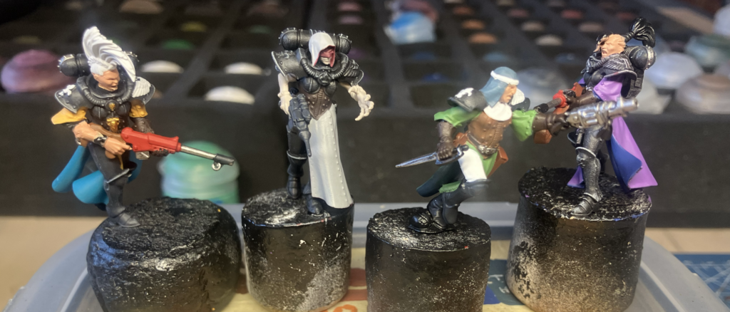Four kitbashed Escher sisters of battle in mid-paint