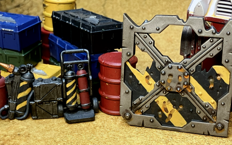 A barricade, repair kit, and barrel with hazard stripes.