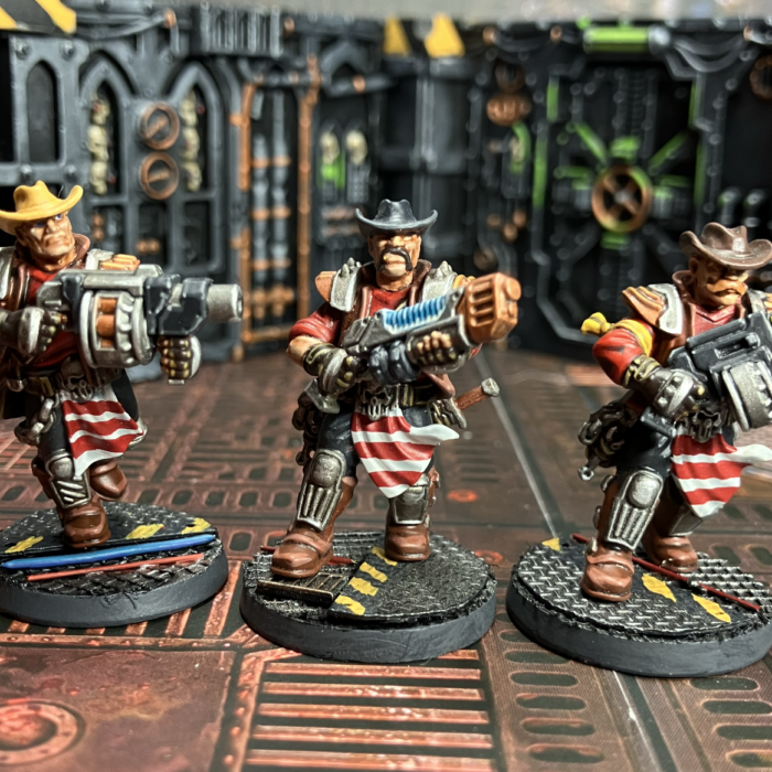 Three Orlock champions, one with a grenade launcher, one with a plasma gun, one with a bolter