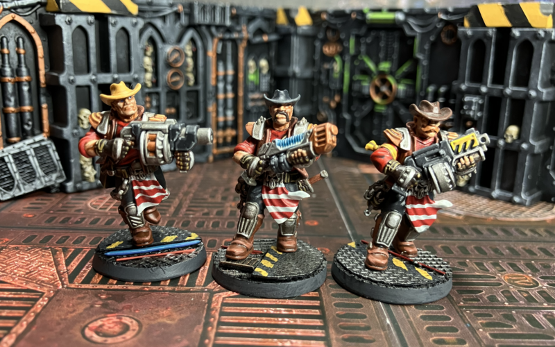 Three Orlock champions, one with a grenade launcher, one with a plasma gun, one with a bolter