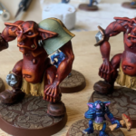 Two trolls for snotlings, slightly modified and painted red and lighter red and red and orange.