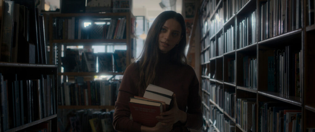 Maria carrying books in her book store in Dark Matter