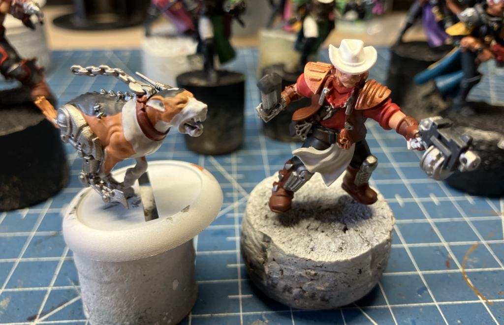 An orlock champ with a bolt pistol and chainsword and a cyber-mastiff