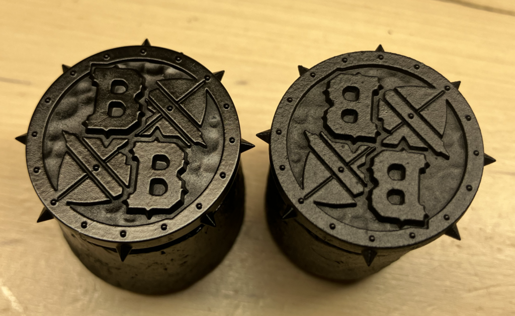 Two blood bowl coins primed, one with Army Painter, one with Green Stuff World